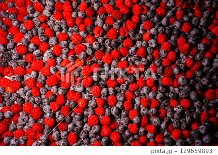 background. The surface is covered with raspberries and blueberries. background. The surface is covered with raspberries and blueberries. 129659893