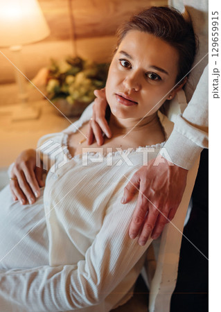 a man gently hugs a pregnant woman by the shoulders. a man gently hugs a pregnant woman by the shoulders. 129659915