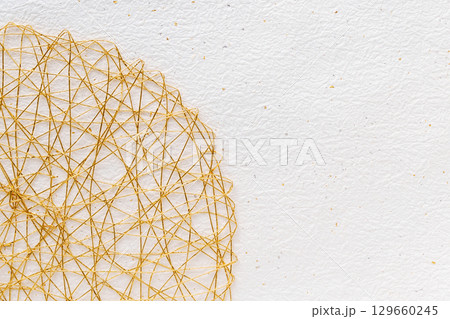 金箔銀箔の白いもみ和紙と金の水引の背景 129660245