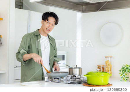 キッチンで料理をする若い男性 129660290