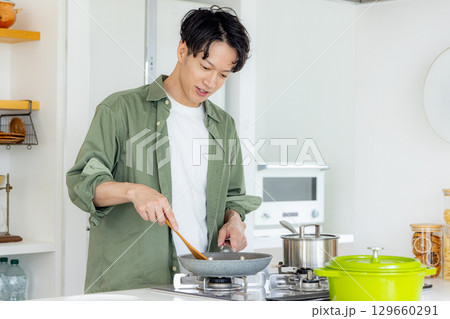 キッチンで料理をする若い男性 129660291