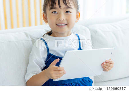 タブレットを見る女の子 129660317