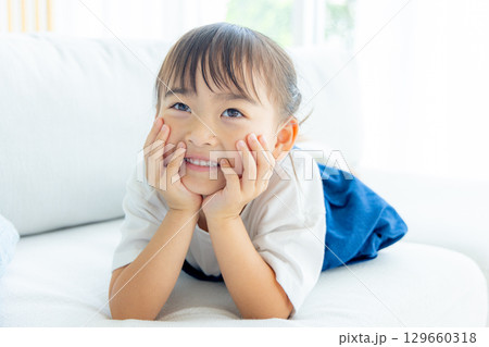 笑顔で頬杖をつく女の子 129660318