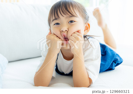 笑顔で頬杖をつく女の子 笑顔で頬杖をつく女の子 129660321