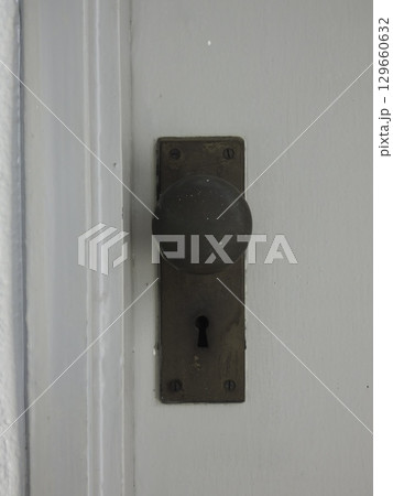 年月を経た真鍮製のドアノブと鍵穴 年月を経た真鍮製のドアノブと鍵穴 129660632