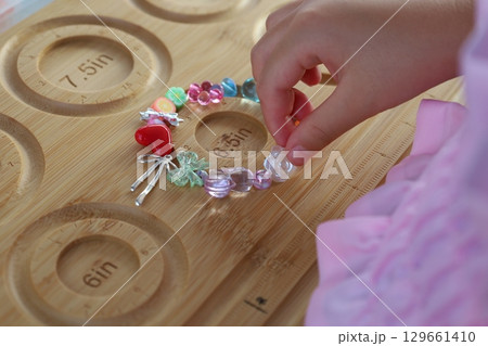 子どもの手によるビーズアクセサリー作り 子どもの手によるビーズアクセサリー作り 129661410