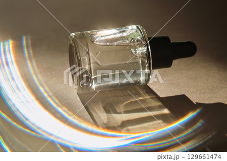 Natural facial oil with beautiful highlights on a beige background. Natural facial oil with beautiful highlights on a beige background. 129661474