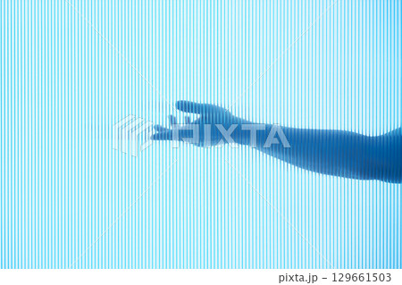 An outstretched hand behind a transparent blue background. 129661503