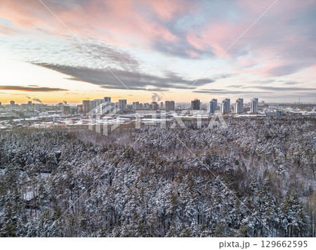 Aerial view of a winter pine forest. Top view of snow-covered pine trees. Beautiful winter forest landscape. Aerial view of a winter pine forest. Top view of snow-covered pine trees. Beautiful winter forest landscape. 129662595