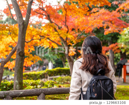 紅葉を見る女性の後ろ姿 129663108