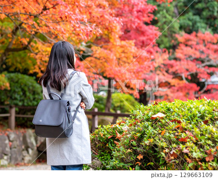 紅葉を見る女性の後ろ姿 129663109