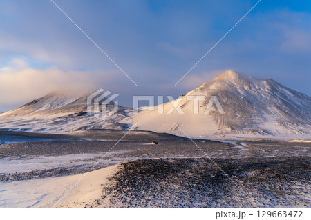 夕日に輝くアイスランド高地の雪山 129663472