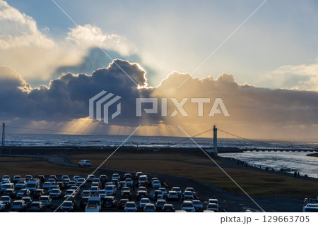 駐車場から見たヨークルスアゥルロゥン氷河湖の吊り橋と光芒（アイスランド） 129663705