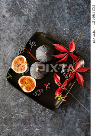 Fresh figs on black plate. Dark background. Close up. Top view. Fresh figs on black plate. Dark background. Close up. Top view. 129663853
