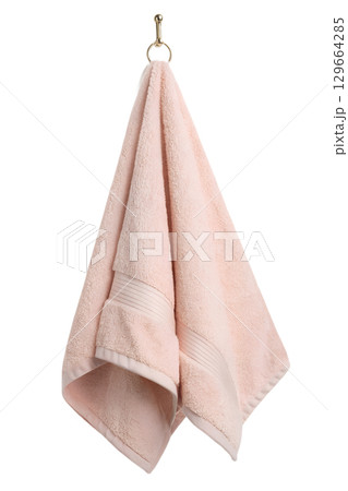 Soft pink cotton towel hanging on wooden hook, bathroom linen isolated Soft pink cotton towel hanging on wooden hook, bathroom linen isolated 129664285