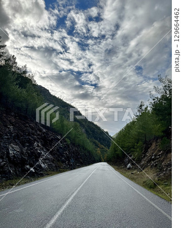 Mountainous road sky. Cloudy road landscape. High quality photo Mountainous road sky. Cloudy road landscape. High quality photo 129664462