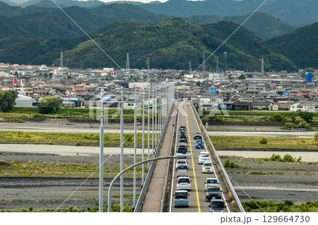 静岡県島田市の島田大橋を渡る車と山あいの町並み, 129664730