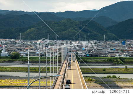 静岡県島田市の島田大橋を渡る車と山あいの町並み, 129664731