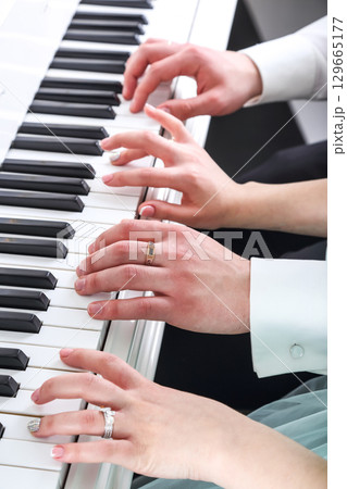 Couple playing piano together with elegant hands showcasing musical harmony and joy 129665177