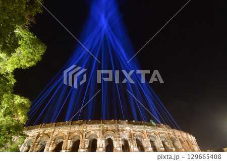 ニーム、フランス。イベントの光が漏れる、夜のローマ円形闘技場。2025年8月12日撮影。 129665408