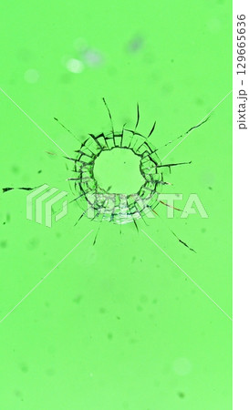 Bullet Destruction. Dirty Glass Broken into a Large Number of Pieces and Parts, a Piece of Glass with a lot of Cracks and Broken Parts. Isolated on Black Background. 129665636