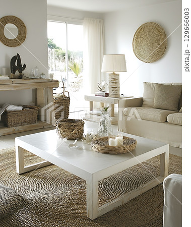 A living room with a white coffee table and a beige couch A living room with a white coffee table and a beige couch 129666003