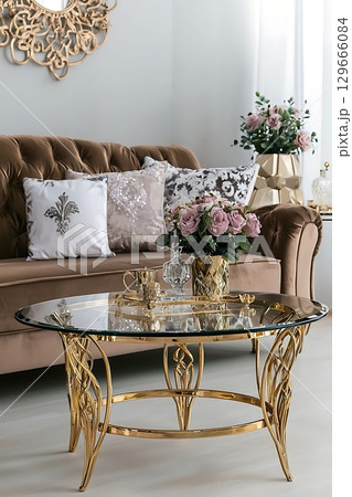 A gold coffee table with a vase of flowers on top 129666084