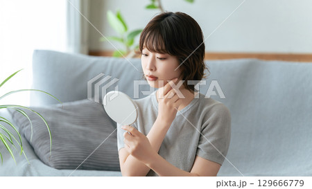 鏡で肌をチェックする女性 鏡で肌をチェックする女性 129666779