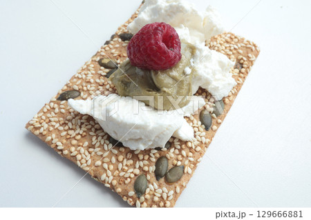 Crispy grain breads with seeds, cheese, ricotta and berries, marmalade. Breakfast and healthy eating. Crispy grain breads with seeds, cheese, ricotta and berries, marmalade. Breakfast and healthy eating. 129666881