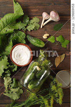 Homemade pickling recipe, cucumbers and pickling ingredients, home canning concept.Fresh pickled cucumbers in a bowl with garlic and dill on a concrete table, village harvest Homemade pickling recipe, cucumbers and pickling ingredients, home canning concept.Fresh pickled cucumbers in a bowl with garlic and dill on a concrete table, village harvest 129669458