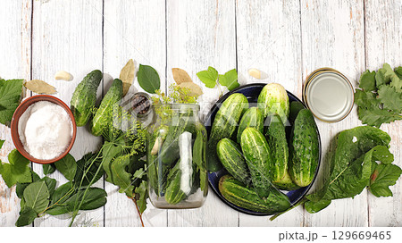 Homemade pickling recipe, cucumbers and pickling ingredients, Pickled cucumbers in jars with garlic and dill on wooden kitchen table, rustic style, home canning concept Homemade pickling recipe, cucumbers and pickling ingredients, Pickled cucumbers in jars with garlic and dill on wooden kitchen table, rustic style, home canning concept 129669465