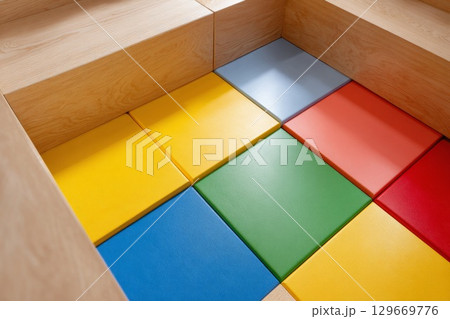 Colorful rubber flooring tiles arranged in a playful pattern for children's play area design Colorful rubber flooring tiles arranged in a playful pattern for children's play area design 129669776