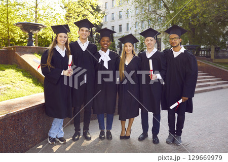 Ready to success. Six college graduates standing in a row and smiling. 129669979