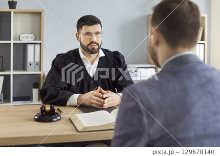 Judge, law professional solicitor or barrister, attorney in court of law talking to client Judge, law professional solicitor or barrister, attorney in court of law talking to client 129670140