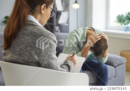 Therapy session for man by psychologist, crisis counseling of male client with stress in office Therapy session for man by psychologist, crisis counseling of male client with stress in office 129670143