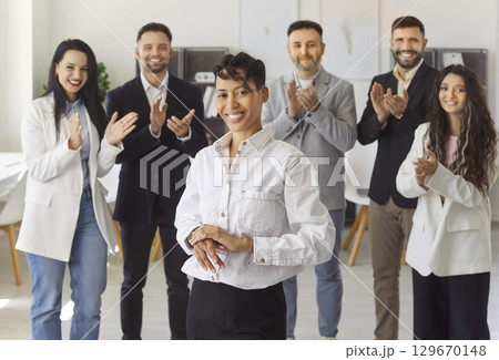 Support and compliments, applause to proud happy woman from corporate employee team in office 129670148