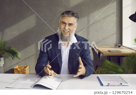 Smiling businessman entrepreneur in suit talking to camera 129670254