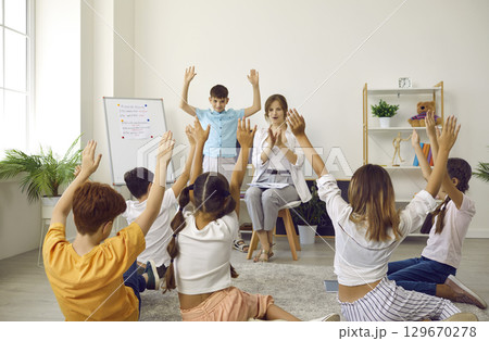 Happy school students with teacher playing games and having fun in the classroom Happy school students with teacher playing games and having fun in the classroom 129670278