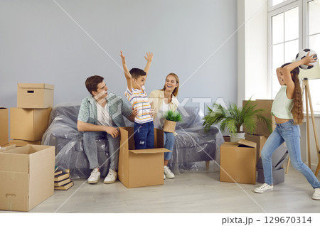 Active joyful children enjoy moving day and play, have fun and fool around in new house. Active joyful children enjoy moving day and play, have fun and fool around in new house. 129670314