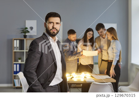 Portrait Of Serious Businessman With Team In Office Portrait Of Serious Businessman With Team In Office 129670315