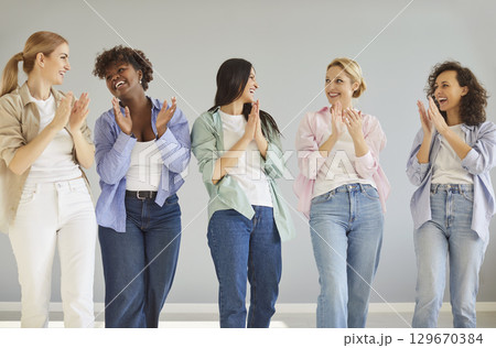 Happy successful diverse smiling young girls applauding, best friends, multiracial attractive group  129670384