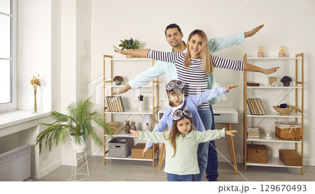 Happy little children together with their parents playing and flying planes at home 129670493