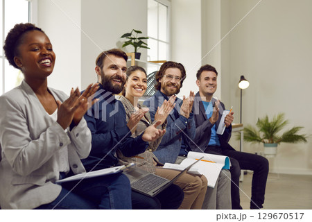 Professional audience applauding the speaker after a good presentation in a business meeting Professional audience applauding the speaker after a good presentation in a business meeting 129670517