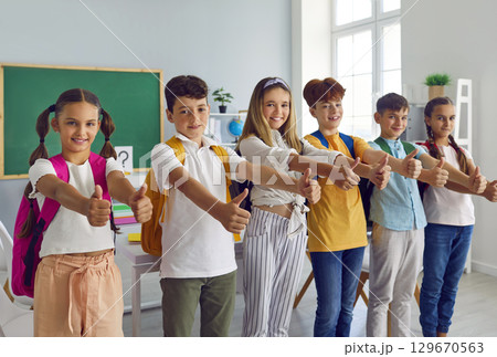 Group of students in classroom show their thumbs up to show their approval of great choice. 129670563