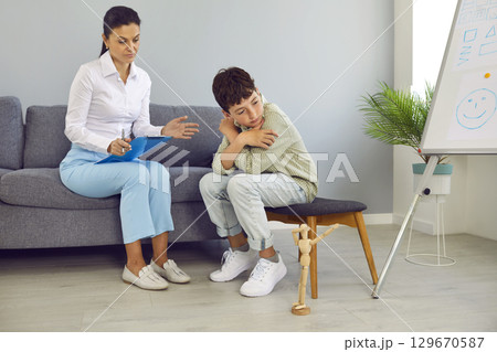 Therapist or psychologist trying to talk to a sad, upset, depressed little child 129670587