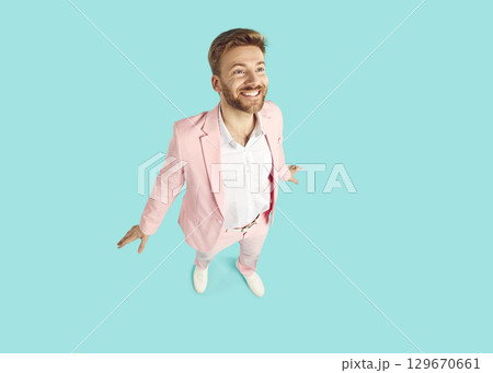 Portrait of a young funny surprised bearded man isolated on studio blue background 129670661