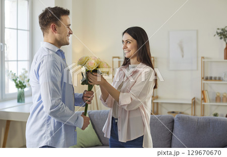 Husband presenting wife with flowers, have romantic relationship Husband presenting wife with flowers, have romantic relationship 129670670