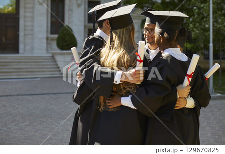 Diversity group of happy graduates celebrating graduation at university campus outdoors. 129670825