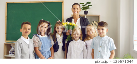 Portrait of first grade students with their female class teacher on first day of school. 129671044