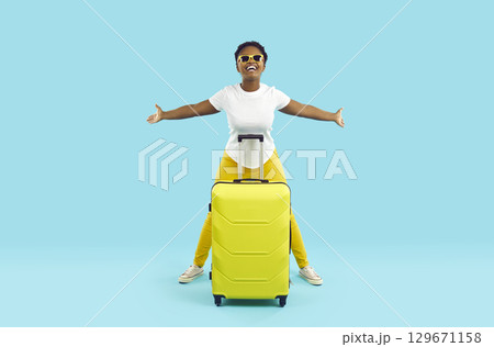 Happy excited african american female tourist with suitcase is happy about new trip. Happy excited african american female tourist with suitcase is happy about new trip. 129671158